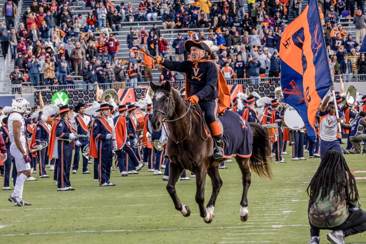 Cav Man storming through Scott Stadium with CMB members cheering after the pregame show. (Photo Credit: Tom Pajewski)